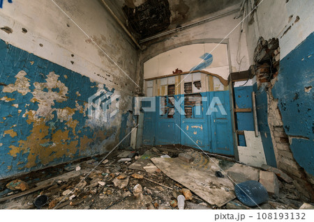 From above interior of dirty peeling paint walls with broken ceiling wooden furniture on heap of strewn rubble on floor and cracked concrete construction room in daylight From above interior of dirty peeling paint walls with broken ceiling wooden furniture on heap of strewn rubble on floor and cracked concrete construction room in daylight 108193132