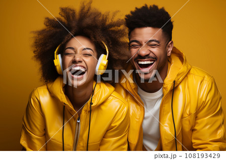 joyful couple of teenagers dancing, enjoying cool music in stereo headphones, listening to a pleasant popular track, actively moving on a yellow background, wearing yellow clothes and with yellow joyful couple of teenagers dancing, enjoying cool music in stereo headphones, listening to a pleasant popular track, actively moving on a yellow background, wearing yellow clothes and with yellow 108193429