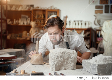 Craftsman hands working with stone sculptor at creative workplace in the atmospheric studio. Craftsman hands working with stone sculptor at creative workplace in the atmospheric studio. 108194090