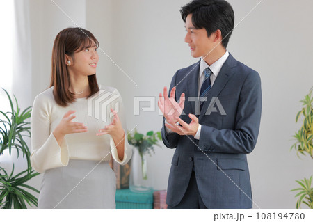 オフィスで身振りを交え打ち合わせるビジネスパーソン男女1 オフィスで身振りを交え打ち合わせるビジネスパーソン男女1 108194780