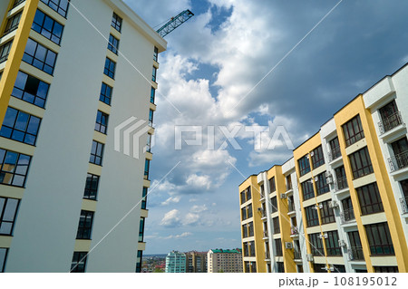 Architectural details of modern high apartment building facade with many windows and balconies Architectural details of modern high apartment building facade with many windows and balconies 108195012
