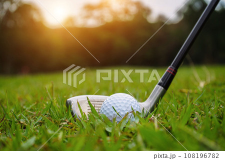Golf ball and golf club in beautiful golf course at sunset background. Golf ball and golf club in beautiful golf course at sunset background. 108196782