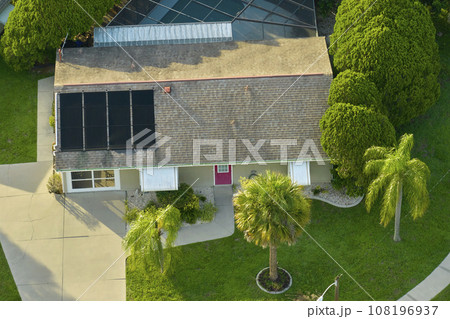 Aerial view of typical contemporary american private house with roof top covered with asphalt shingles and green lawn on yard Aerial view of typical contemporary american private house with roof top covered with asphalt shingles and green lawn on yard 108196937