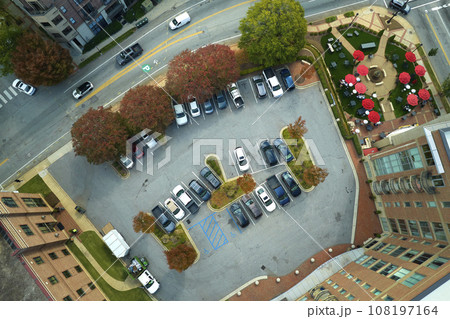 Aerial view of many colorful cars parked on parking lot on apartment building backyard. Place for vehicles in front of residential condo Aerial view of many colorful cars parked on parking lot on apartment building backyard. Place for vehicles in front of residential condo 108197164