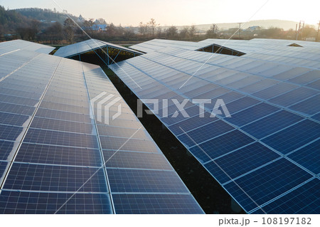 Aerial view of large sustainable electrical power plant with rows of solar photovoltaic panels for producing clean ecological electric energy. Renewable electricity with zero emission concept. Aerial view of large sustainable electrical power plant with rows of solar photovoltaic panels for producing clean ecological electric energy. Renewable electricity with zero emission concept. 108197182