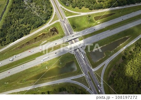 Aerial view of freeway overpass junction with fast moving traffic cars and trucks. Interstate transportation infrastructure in USA 108197272