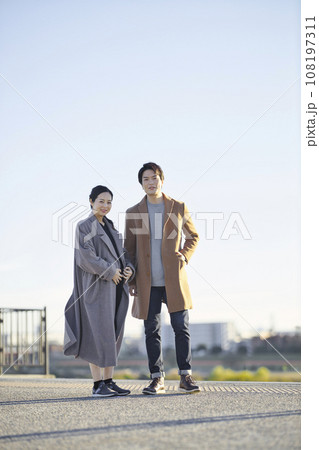 夕暮れに公園を散歩する妊婦と男性 108197311