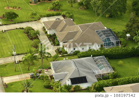 Aerial landscape view of suburban private houses between green palm trees in Florida quiet rural area Aerial landscape view of suburban private houses between green palm trees in Florida quiet rural area 108197542