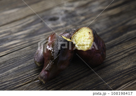 焼きたて熱々の焼き芋( 鳴門金時 )秋の味覚 古板バック 焼きたて熱々の焼き芋( 鳴門金時 )秋の味覚 古板バック 108198417