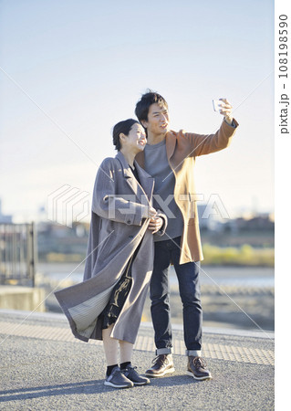 夕暮れに公園を散歩する妊婦と男性 108198590