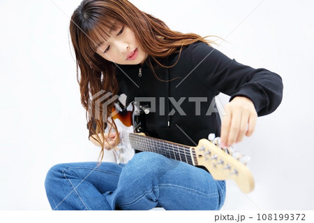 エレキギターをチューニングする女性イメージ エレキギターをチューニングする女性イメージ 108199372