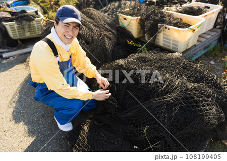 網を手入れする漁師さん 108199405