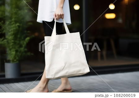 Model hold blank white fabric mockup bag for save environment on street fashion 108200019