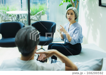 リビングで会話するシニア夫婦 108200592