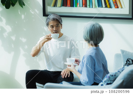 リビングで会話するシニア夫婦 108200596
