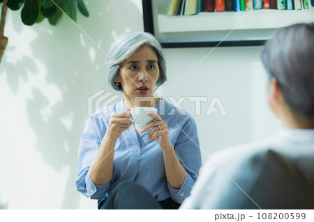 リビングで会話するシニア夫婦 108200599