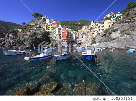 Riomaggiore village skyline with Ligurian Sea and boats on the foreground, Italy 108201151