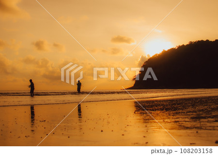 Layan Beach, Phuket, Thailand,Silhouette  Asian man standing fishing at the sea as the sun sets, 108203158