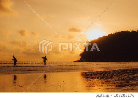 Layan Beach, Phuket, Thailand,Silhouette  Asian man standing fishing at the sea as the sun sets, 108203176