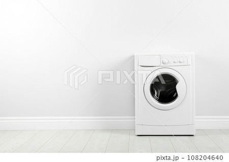 Modern washing machine near white wall, space for text. Laundry day 108204640