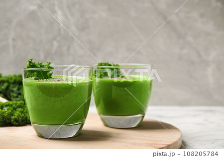 Tasty kale smoothie on marble table, closeup Tasty kale smoothie on marble table, closeup 108205784