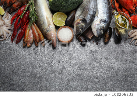 Fresh fish and different seafood on grey table, flat lay. Space for text 108206232