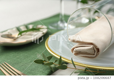 Stylish tableware with leaves on table. Festive setting Stylish tableware with leaves on table. Festive setting 108206687