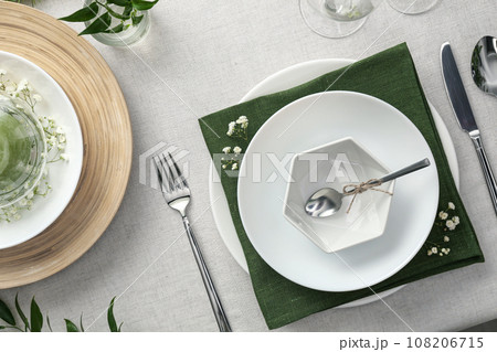Elegant table setting with green plants on light cloth, flat lay 108206715