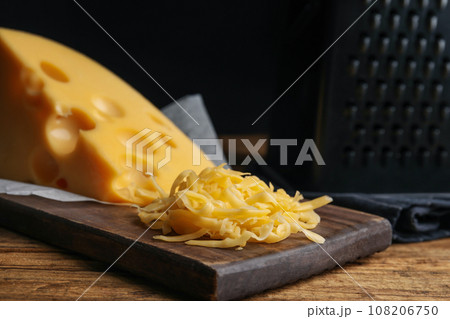 Tasty grated cheese on wooden table, closeup 108206750