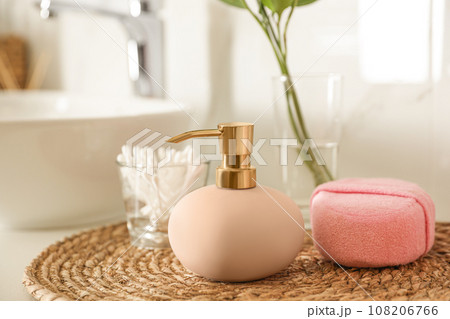 Dispenser, cotton swabs and sponge on countertop in bathroom Dispenser, cotton swabs and sponge on countertop in bathroom 108206766