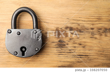 Steel padlock and space for text on wooden background, top view. Safety concept Steel padlock and space for text on wooden background, top view. Safety concept 108207050