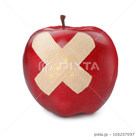 Red ripe apple with sticking plasters isolated on white Red ripe apple with sticking plasters isolated on white 108207097