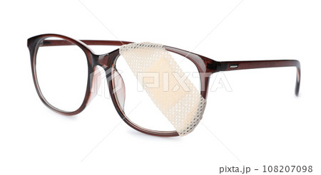 Glasses with sticking plaster isolated on white Glasses with sticking plaster isolated on white 108207098