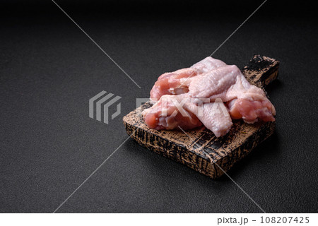 Fresh raw chicken wings with salt and spices prepared for baking 108207425