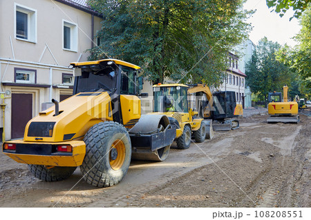 Road construction equipment: excavators, asphalt rollers, bulldozers on a city street with the road surface removed. Equipment for repair and laying of road surfaces Road construction equipment: excavators, asphalt rollers, bulldozers on a city street with the road surface removed. Equipment for repair and laying of road surfaces 108208551