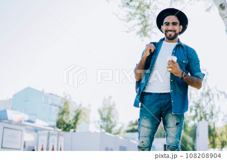 Happy bearded male walking on meadow in park Happy bearded male walking on meadow in park 108208904