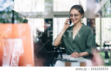 Young smiling woman talking on smartphone with closed eyes Young smiling woman talking on smartphone with closed eyes 108208959