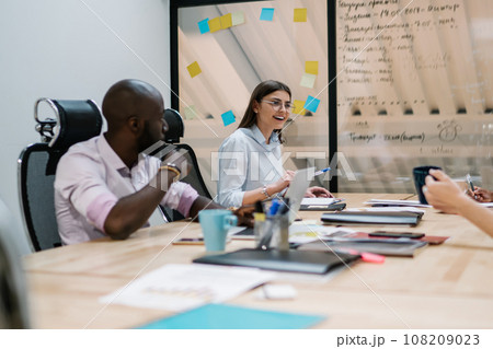Excited employee discussing project with colleagues at workplace 108209023