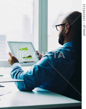 Man exploring graphs on tablet 108209122