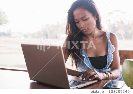 Ethnic woman working on project using laptop in cafe 108209149