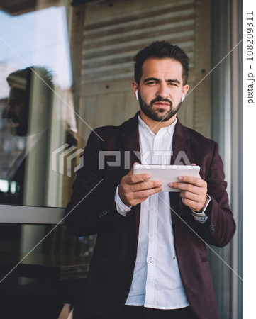 Serious boss using tablet near window 108209311