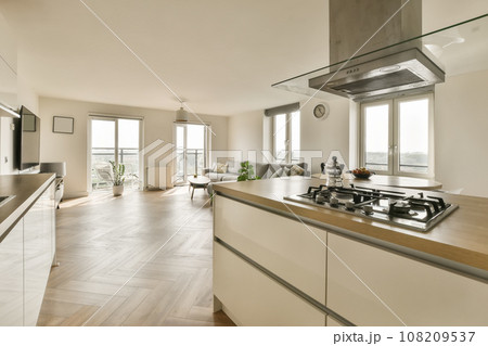 a modern kitchen with wood flooring and stainless steel range hoods on the stovetop in this home's living room 108209537