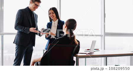 smiling in formal wear traders introducing touchpad for online communication 108209550
