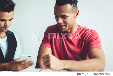 millennial men checking email via cellphone 108209705