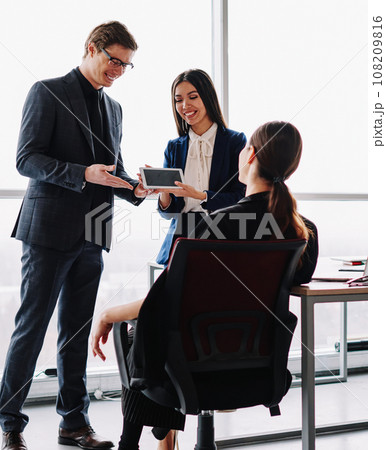 smiling in formal wear traders introducing touchpad for online communication smiling in formal wear traders introducing touchpad for online communication 108209816