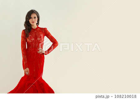 Beauty woman with earrings and red lip makeup wearing red evening gown Beauty woman with earrings and red lip makeup wearing red evening gown 108210018