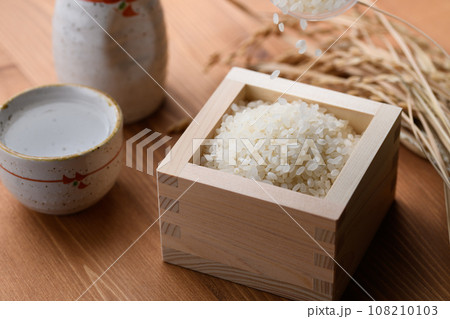 枡に盛ったお米と日本酒の熱燗 （ 白米 ）稲穂 木目バック 108210103