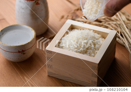 枡に盛ったお米と日本酒の熱燗 ( 白米 )稲穂 木目バック 枡に盛ったお米と日本酒の熱燗 ( 白米 )稲穂 木目バック 108210104