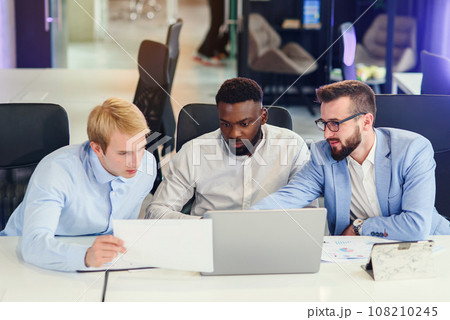Businessmen sitting at the office table and comparing data from report and computer to succeed in corporate working together. 108210245