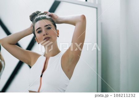 Proud woman tying long hair in white class Proud woman tying long hair in white class 108211232